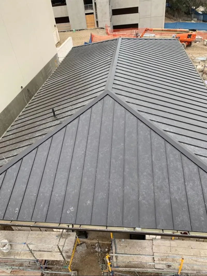 Commercial metal roof construction with crane equipment in Wallingford